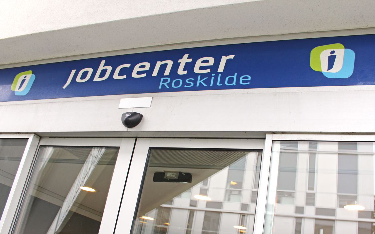 Jobcenter Roskildes indgangsparti med automatiske døre og et blåt skilt.
