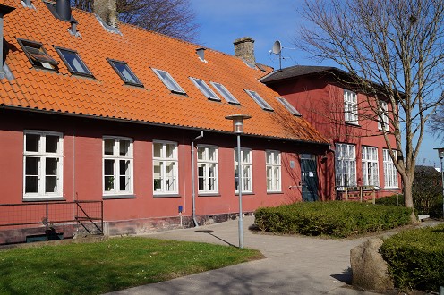 En rød bygning. Det er Alle Tiders Højskole.