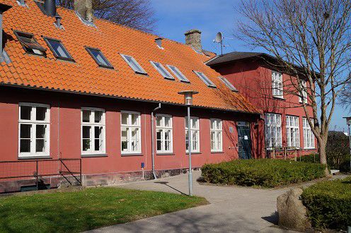 En rød bygning. Det er Alle Tiders Højskole.