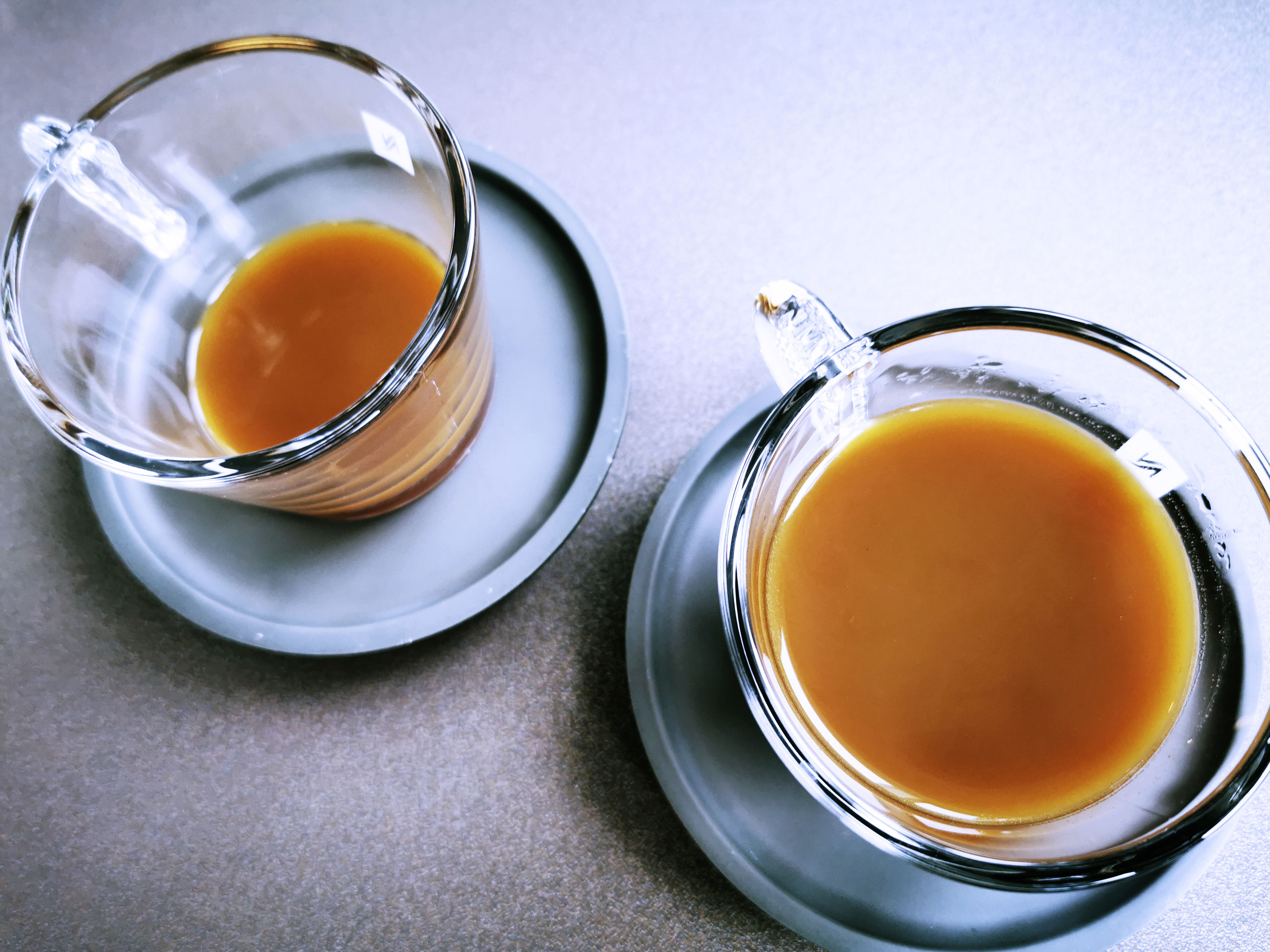 To kopper kaffe i glaskopper. Kaffen er lys - måske med mælk?